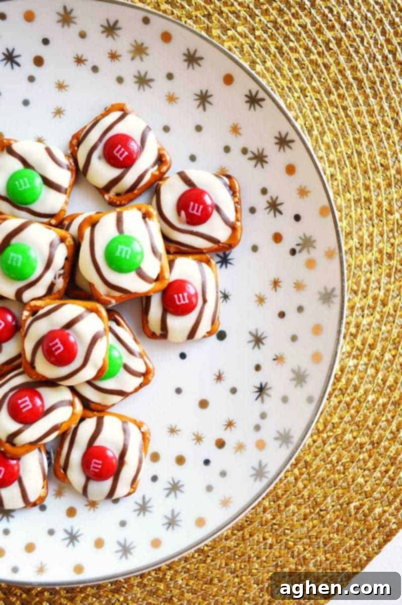 Salty-sweet Christmas pretzel hugs treats are quick and easy to make with just 3 ingredients: square pretzels, M&Ms, and Hershey's Hugs.