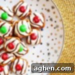 Salty-sweet Christmas pretzel hugs treats are quick and easy to make with just 3 ingredients: square pretzels, M&Ms, and Hershey's Hugs.