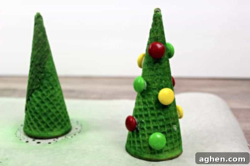 Sugar cones being sprayed with vibrant green edible mist, transforming them into the base for adorable Christmas tree cupcakes.