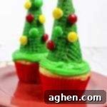 Festive Christmas Tree Cone Cupcakes 9 A square image featuring a festive Christmas tree cupcake made with a sugar cone and colorful M&M decorations.