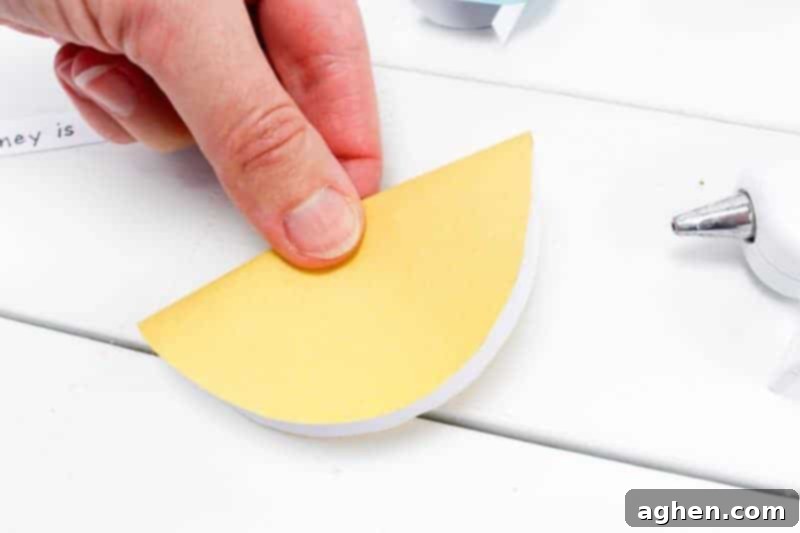 Gently folding a paper circle in half for the first crease.