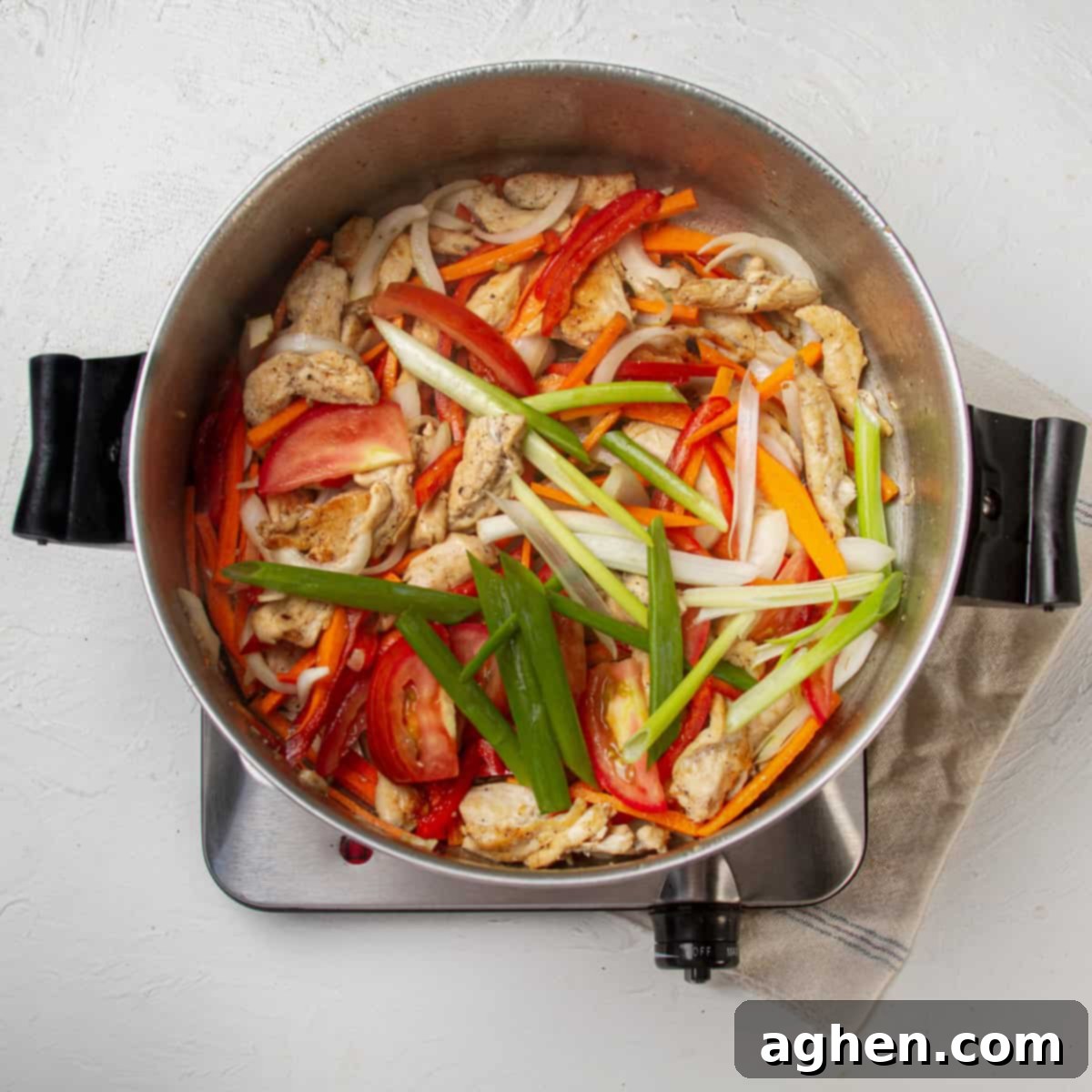 Thai Pad Woon Sen Stir Fry 8 Chicken and matchstick veggies, including carrot, bell pepper, white onion, and green onion, stir-frying in a pan.