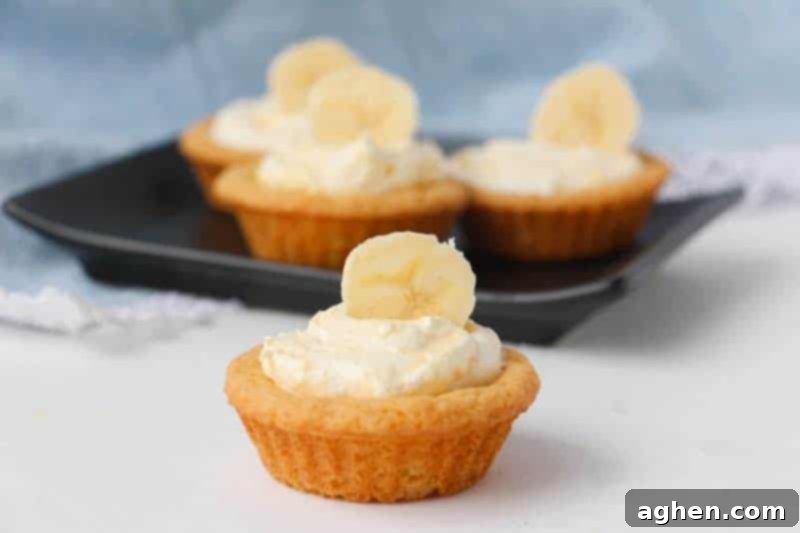 Delicious banana cream cookie cups topped with fresh banana slices, a perfect blend of creamy pudding and a soft cookie base.