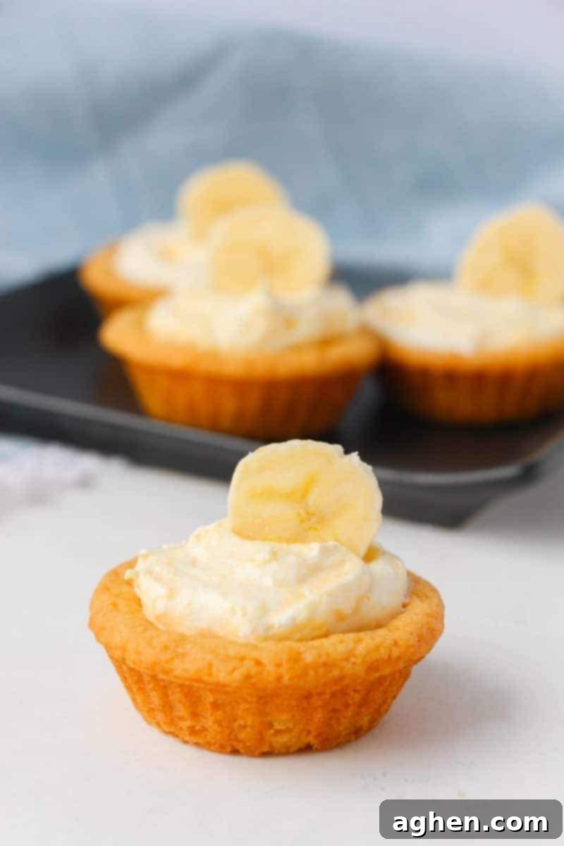 Close-up of a batch of easy banana cream cookie cups, showcasing the golden cookie shells and creamy filling before topping.