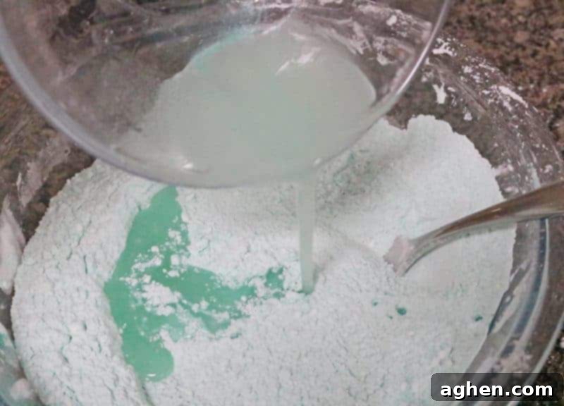 Step 2: The liquid components for the bath bombs, including almond oil, witch hazel, lavender, and peppermint essential oils, are whisked together in a small glass bowl for perfect blending.