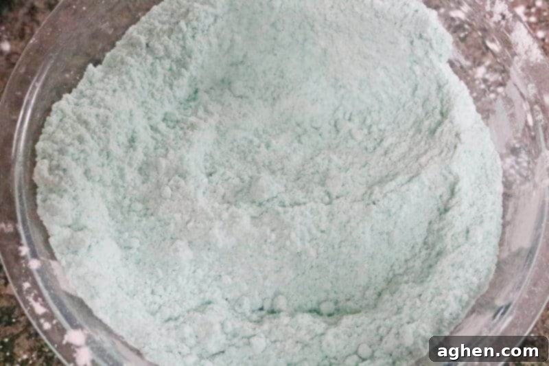 Step 4: Using a fork, the wet and dry bath bomb ingredients are vigorously mixed in a large bowl until they reach a moist, damp-sand-like consistency that is perfect for molding.