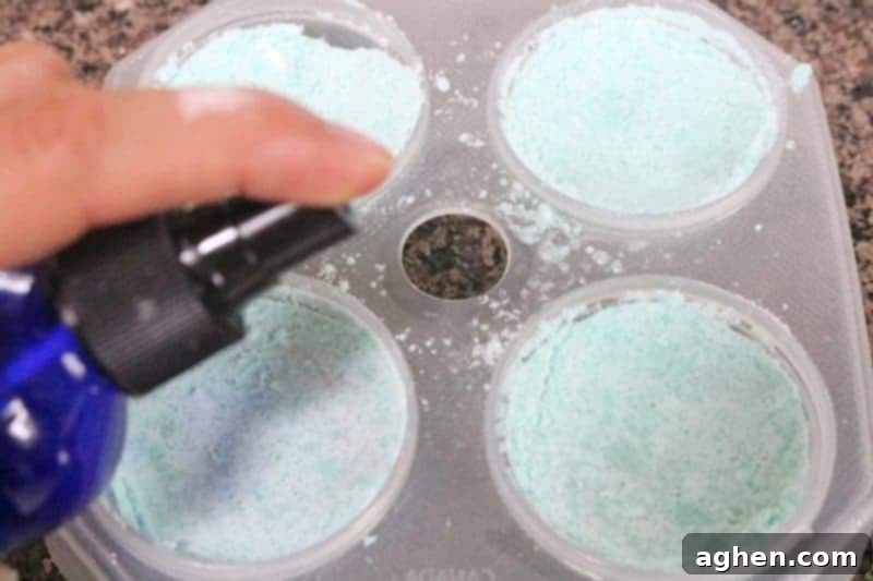 Step 6: The second half of the bath bomb mold is filled and pressed firmly against the first, creating a complete and solid spherical bath bomb, then lightly misted and pressed one last time.