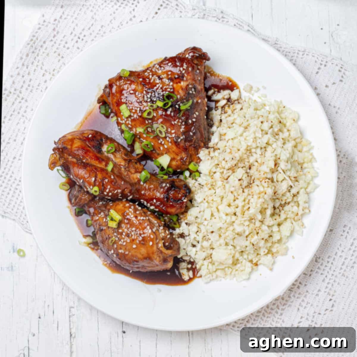 Sweet and sour Shoyu chicken and rice on a plate, garnished with green onions.