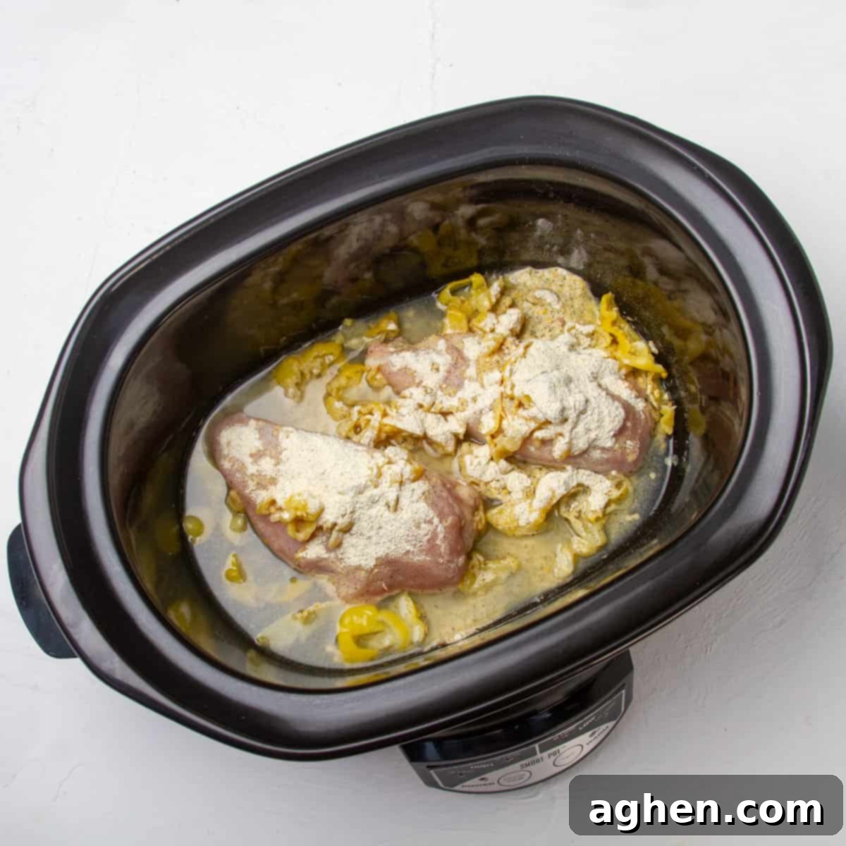 Mississippi Chicken Magic: Your Effortless Slow Cooker Dinner Solution 4 Raw chicken, spices, pickled peppers, and gravy mix in a slow cooker.