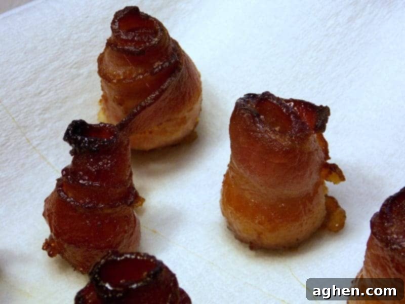 Cooked candied bacon roses cooling and draining on a wire rack, revealing their crispy, caramelized texture.