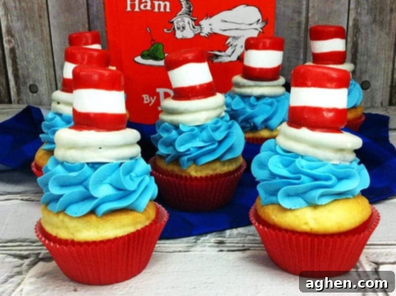 A festive display of Cat in the Hat cupcakes, featuring vibrant blue frosting and iconic red and white striped toppers, perfect for a Dr. Seuss themed party.
