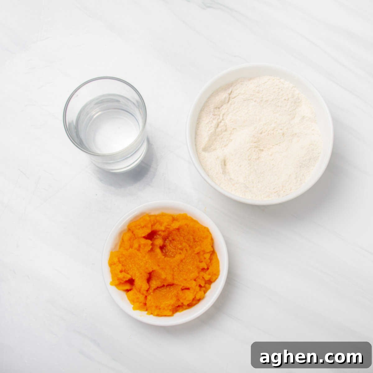 Pumpkin cake mix, pumpkin puree, and water in separate dishes. 
