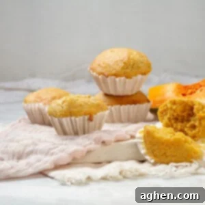 Freshly baked pumpkin muffins in paper liners, arranged on a plate.