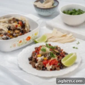 Simple Taco Casserole: Your Taco Night Game Changer 8 Cheesy ground beef taco casserole on a plate, garnished with a lemon wedge and fresh herbs.