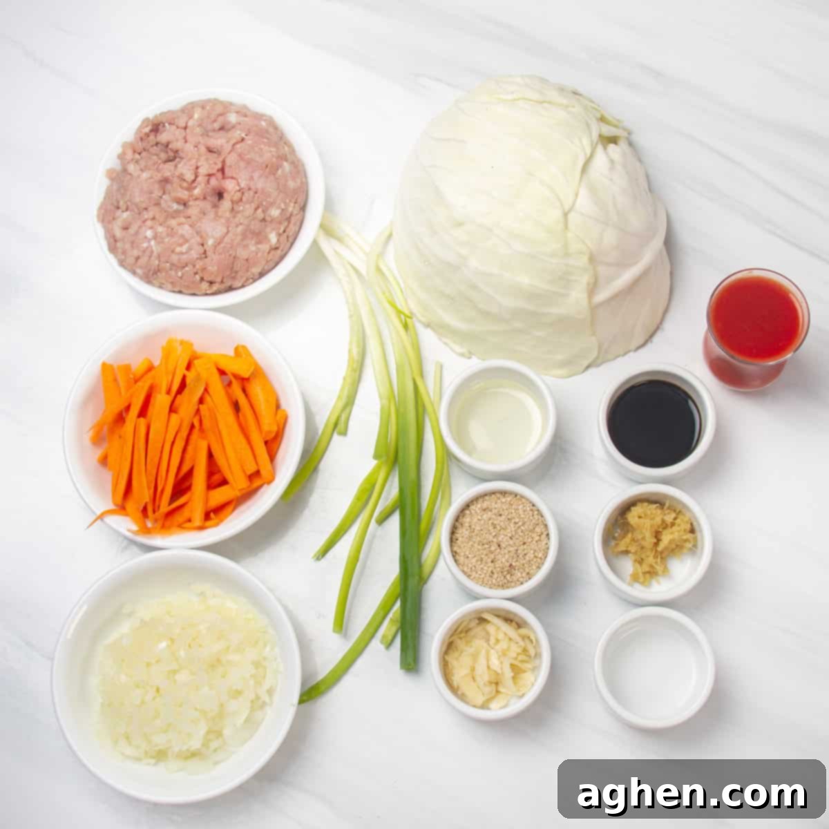 A selection of fresh ingredients neatly arranged in separate dishes, including lean ground chicken, thinly sliced white cabbage, julienned carrots, finely chopped onion, minced garlic, minced fresh ginger, reduced-sodium soy sauce, aromatic sesame oil, tangy rice vinegar, spicy Sriracha sauce, and vibrant green onions for garnish. These form the building blocks for a healthy and flavorful Egg Roll in a Bowl.