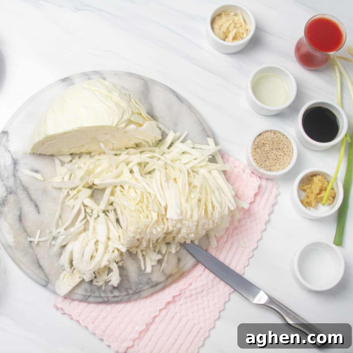 Close-up shot of a small white cabbage, thinly sliced and ready for cooking, illustrating the fine preparation detail needed for the Egg Roll in a Bowl recipe.