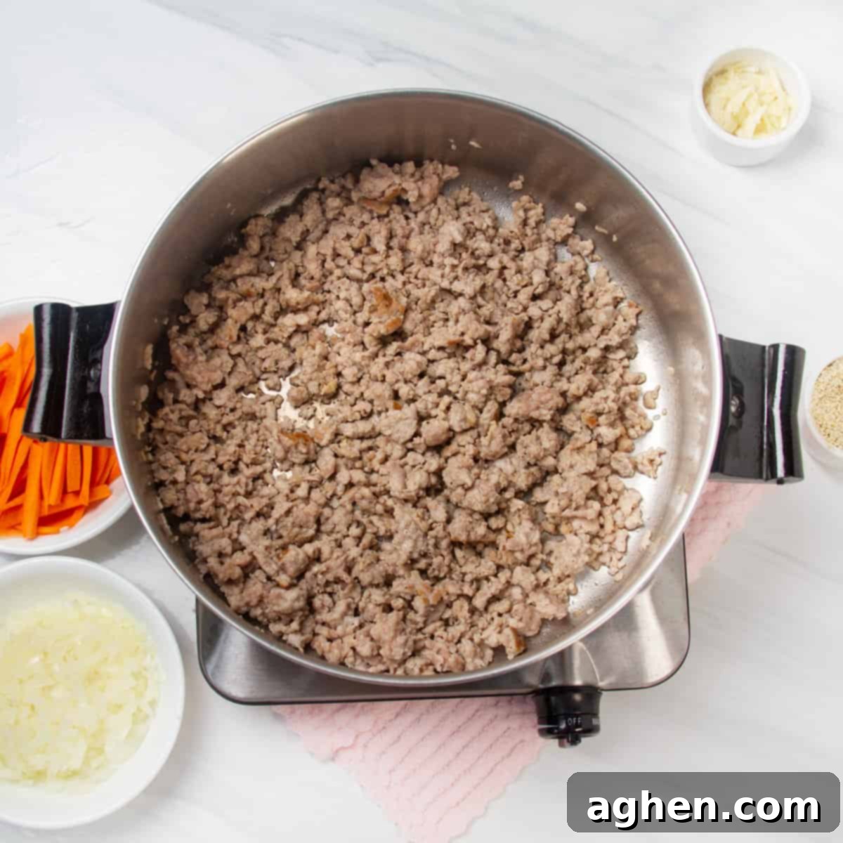 Lean ground chicken being expertly cooked in a large skillet or wok over medium-high heat, showing the process of breaking it apart into crumbles as it browns, a crucial step for the Egg Roll in a Bowl recipe.