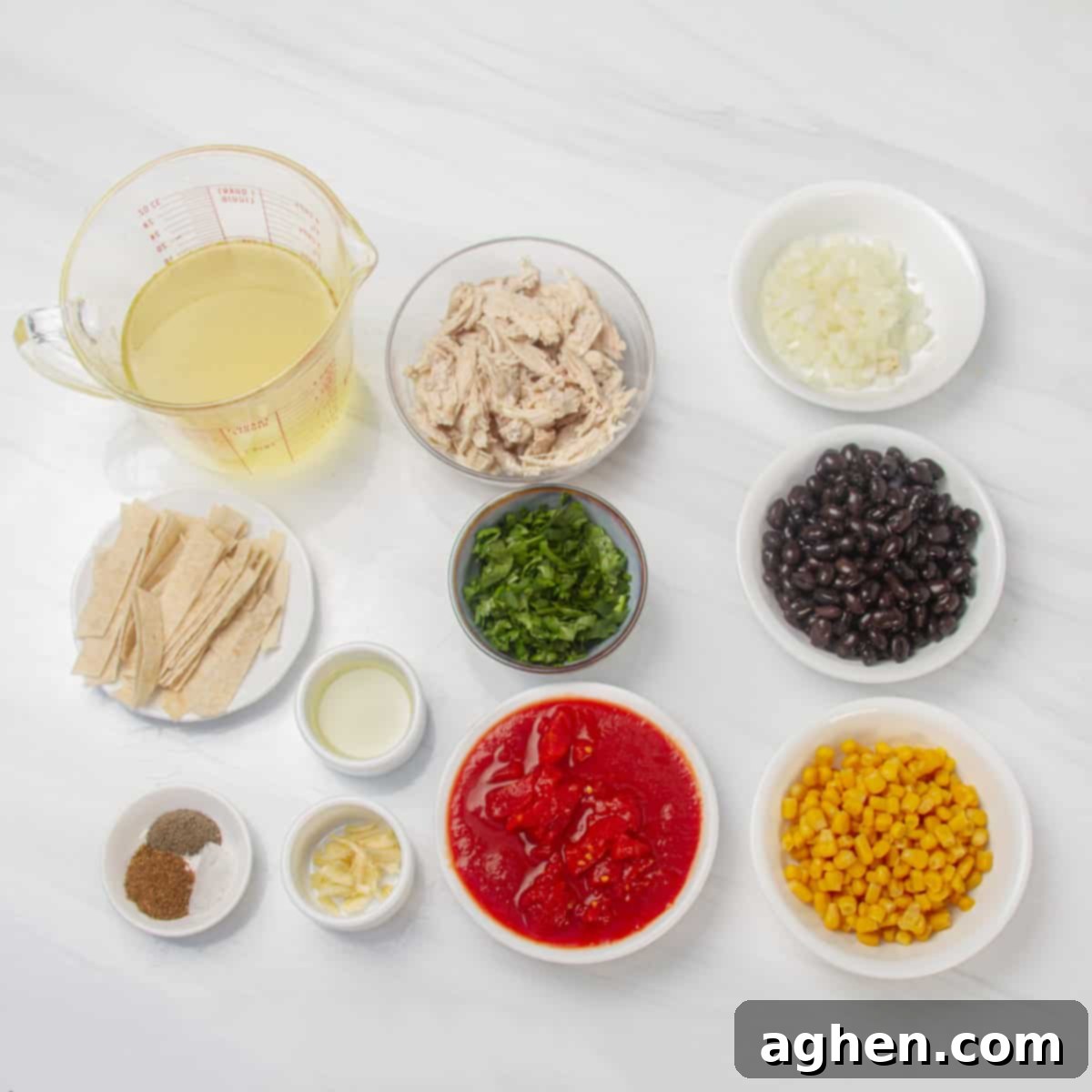 Speedy Skinny Chicken Tortilla Soup 3 A curated display of all necessary ingredients: chicken broth, shredded chicken, diced onion, minced garlic, crushed tomatoes, black beans, corn, tortillas, fresh cilantro, and various seasonings in individual dishes.