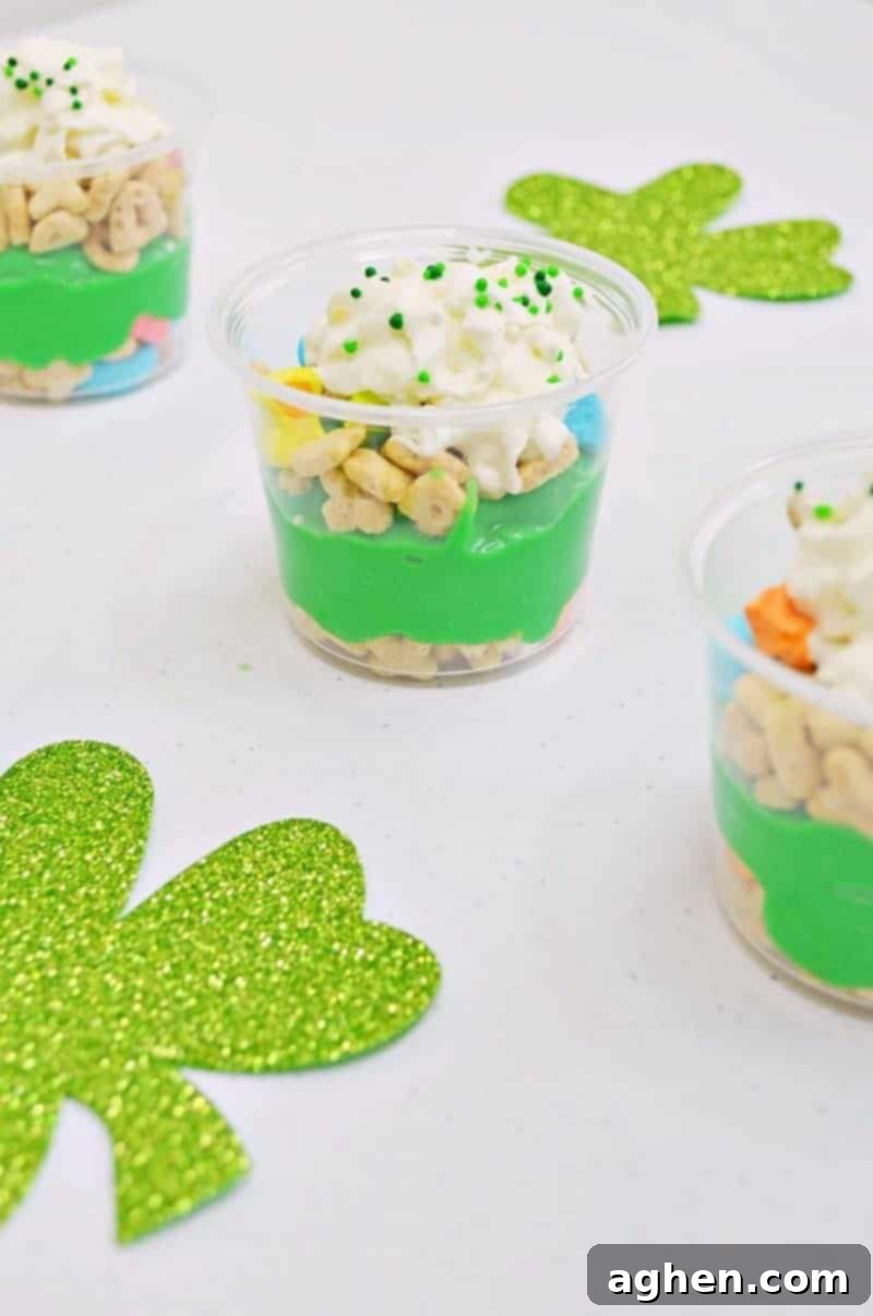 Close-up of a St. Patrick's Day Pudding Parfait cup, showcasing the layers of Lucky Charms and green pudding.