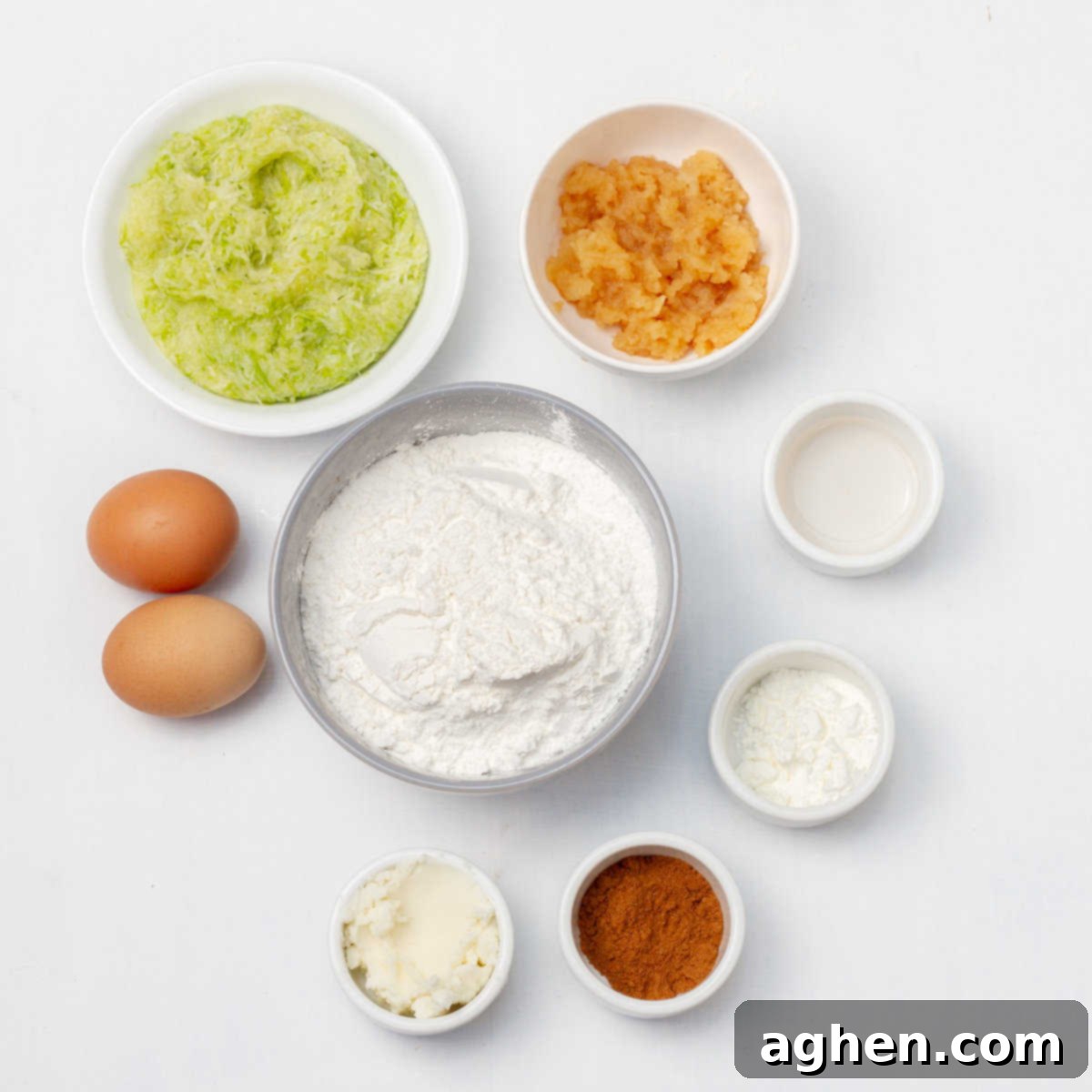 Irresistible Holiday Cinnamon Muffins 3 Ingredients of gluten-free all-purpose flour, baking powder, ground cinnamon, grated apples, stevia, coconut oil, vanilla, grated zucchini, and salt in separate dishes.