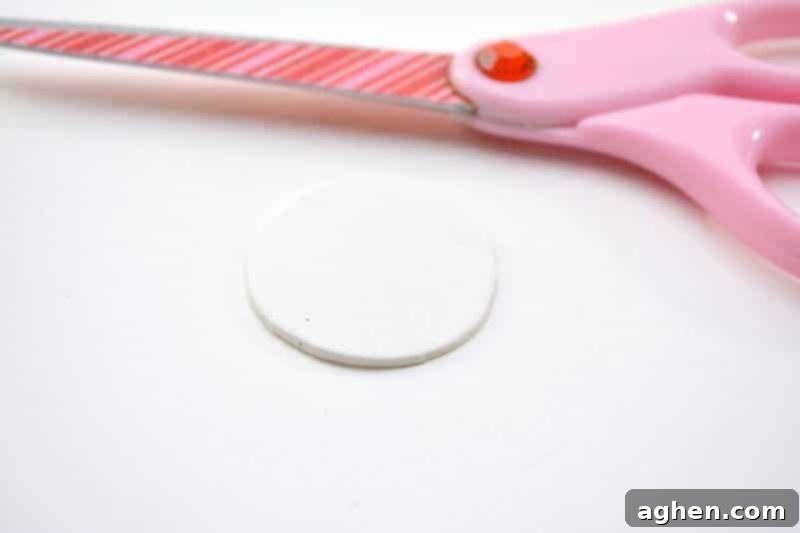 Step-by-step instruction: Cutting a white craft foam circle for the leprechaun's head, an essential first step for your St. Patrick's Day puppet.