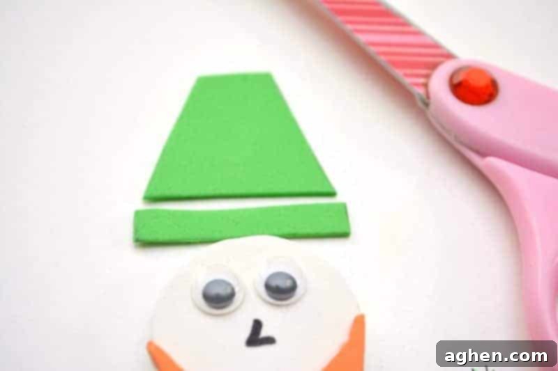 Step-by-step instruction: Cutting green craft foam into a small trapezoid for the hat and a thin rectangle for the brim, preparing the leprechaun's headwear.