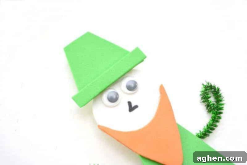 Step-by-step instruction: Gluing the green foam hat to the leprechaun's head and adding the brim, followed by drawing a buckle and buttons for final details.