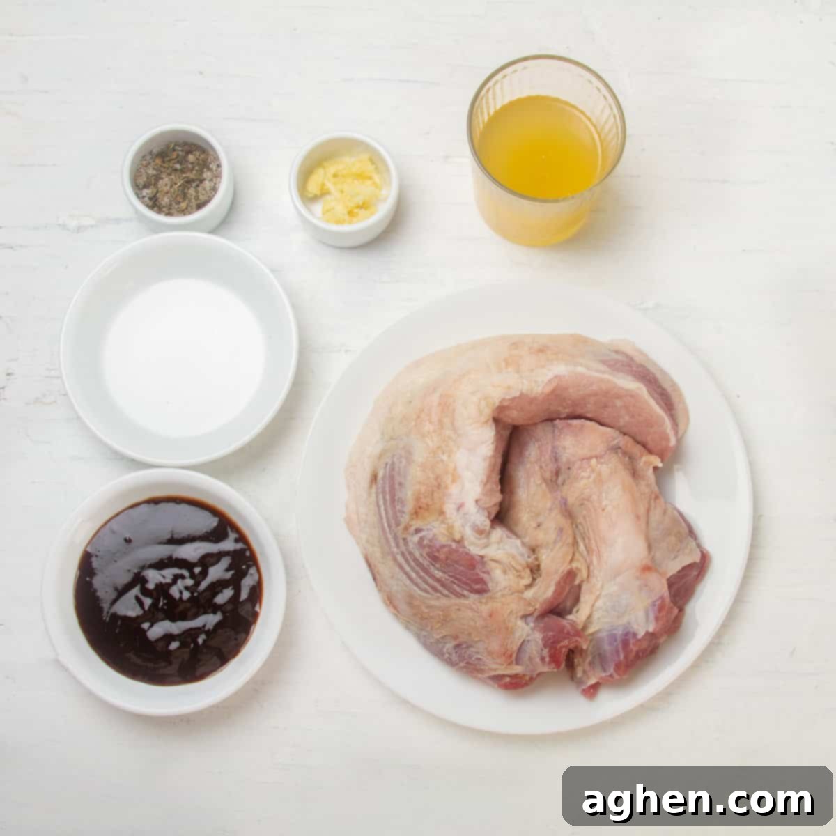 Raw pork shoulder, spices, BBQ sauce, and chicken broth in separate dishes.