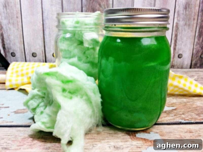 Vibrant green cotton candy moonshine in a clear mason jar, sparkling with edible pearl dust, against a rustic background.