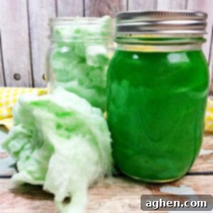 Homemade Green Cotton Candy Moonshine in a glass jar, vibrant and sweet.