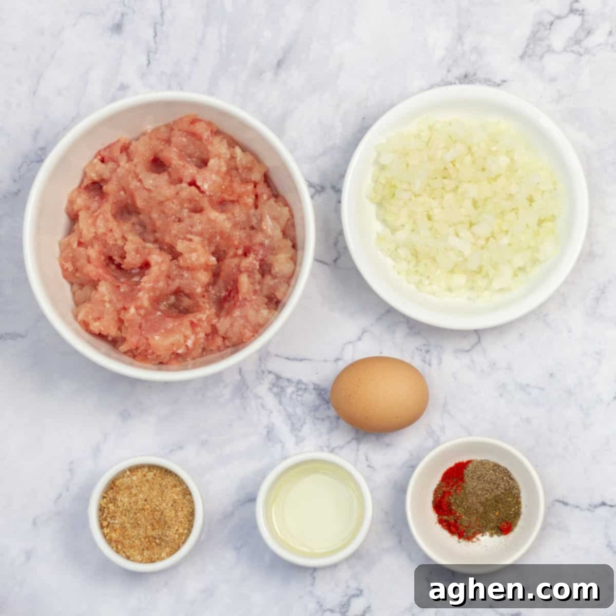 Ingredients of raw ground chicken breast, diced onion, spices, and an egg in separate dishes.
