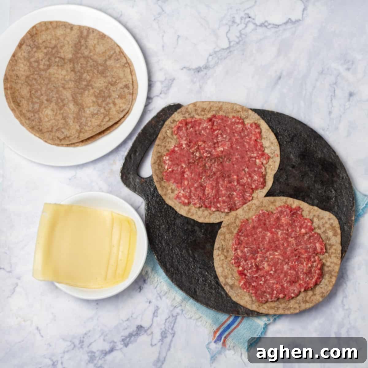 Tortillas pressed with ground beef cooking on a skillet.