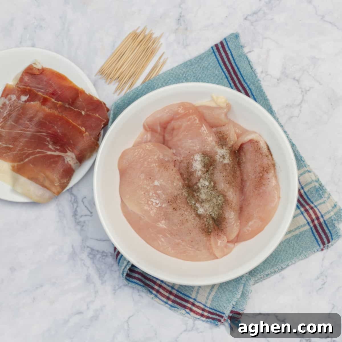 Raw chicken cutlets marinating in salt and pepper seasoning.