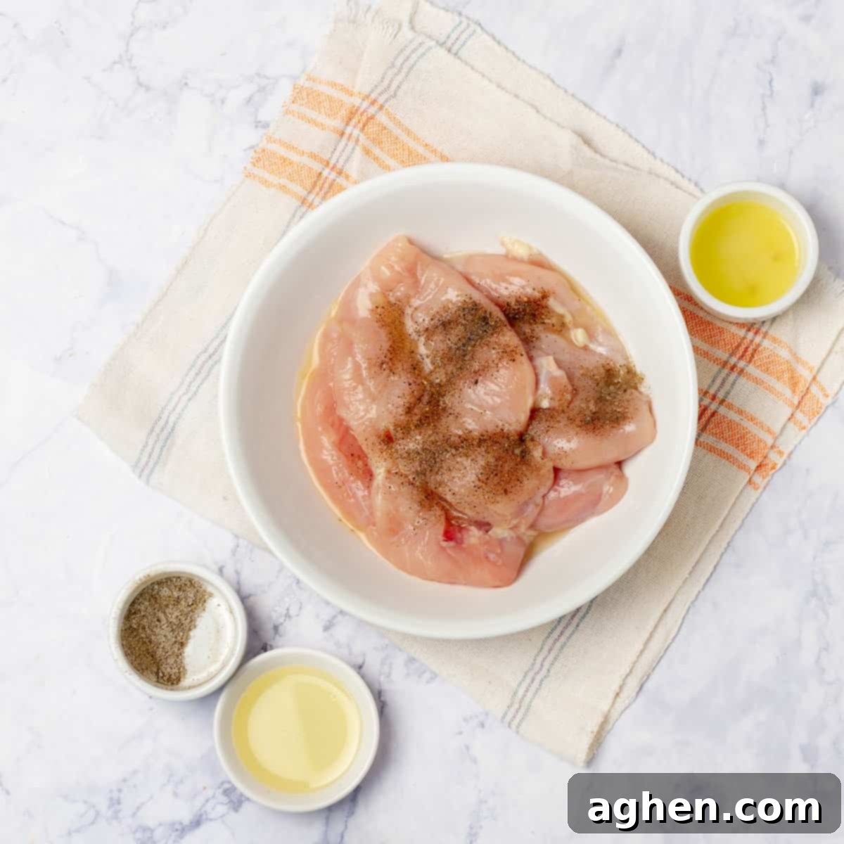 Raw chicken breast marinating in seasonings.