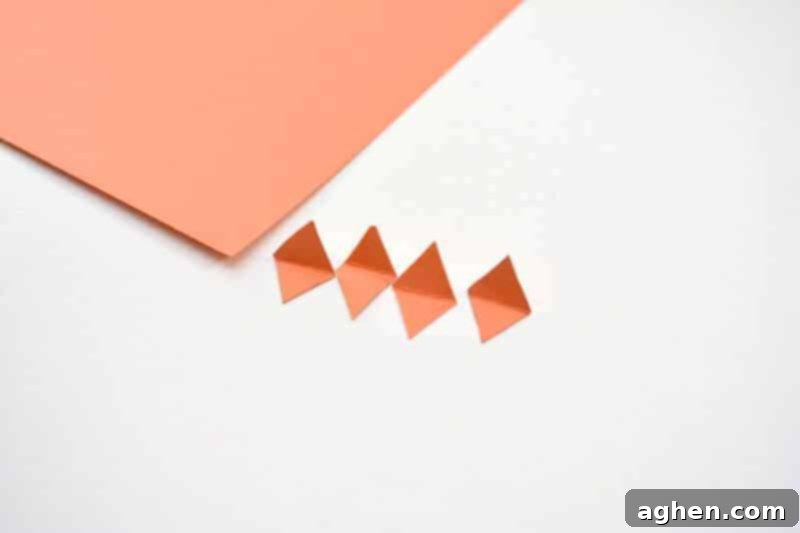 Step 3: Cutting and folding orange cardstock into small diamond shapes for chick beaks.