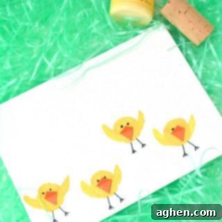 Close-up of a finished Easter chick craft, showing the stamped body, painted wings, and paper beak.