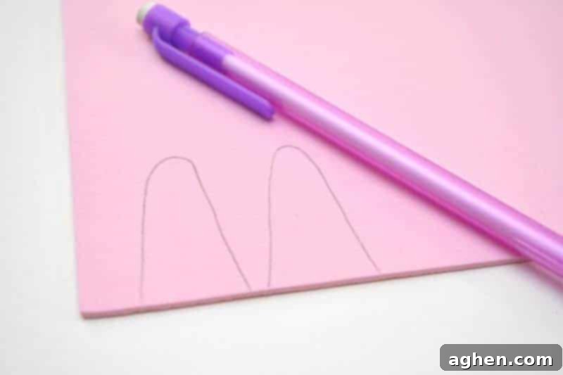 Step 1: Draw the shape of two bunny ears on pink craft foam, using the pudding cup size for reference. Make them tall rounded hills.
