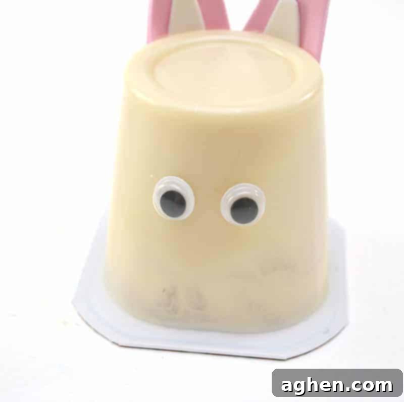 Step 6: Glue a pair of googly eyes to the front of the upside-down pudding cup to give your bunny expression.