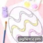 Small thumbnail of child's hand holding a paintbrush, decorating with colorful Peeps puffy paint.