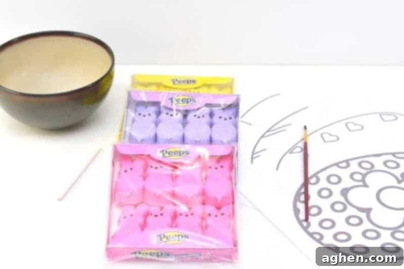 Essential supplies laid out for making Peeps puffy paint: Peeps candy, a microwave-safe bowl, a stirring stick, and a paintbrush.