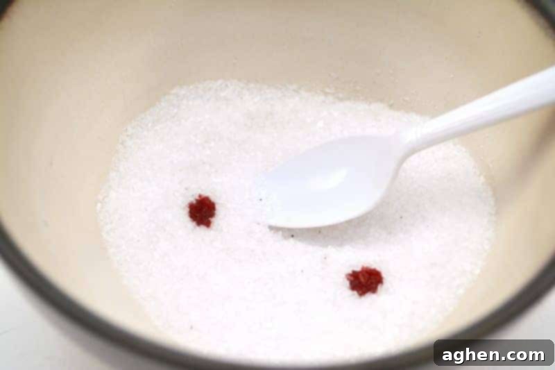 Mixing Epsom salt with green food coloring in a bowl to create homemade salt glitter.