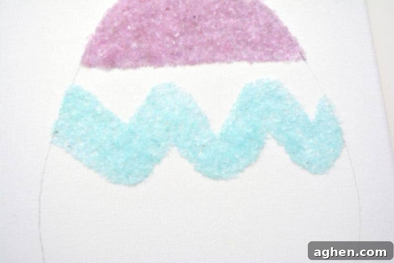 Creating a squiggly line design on the Easter egg canvas using glue and salt glitter.
