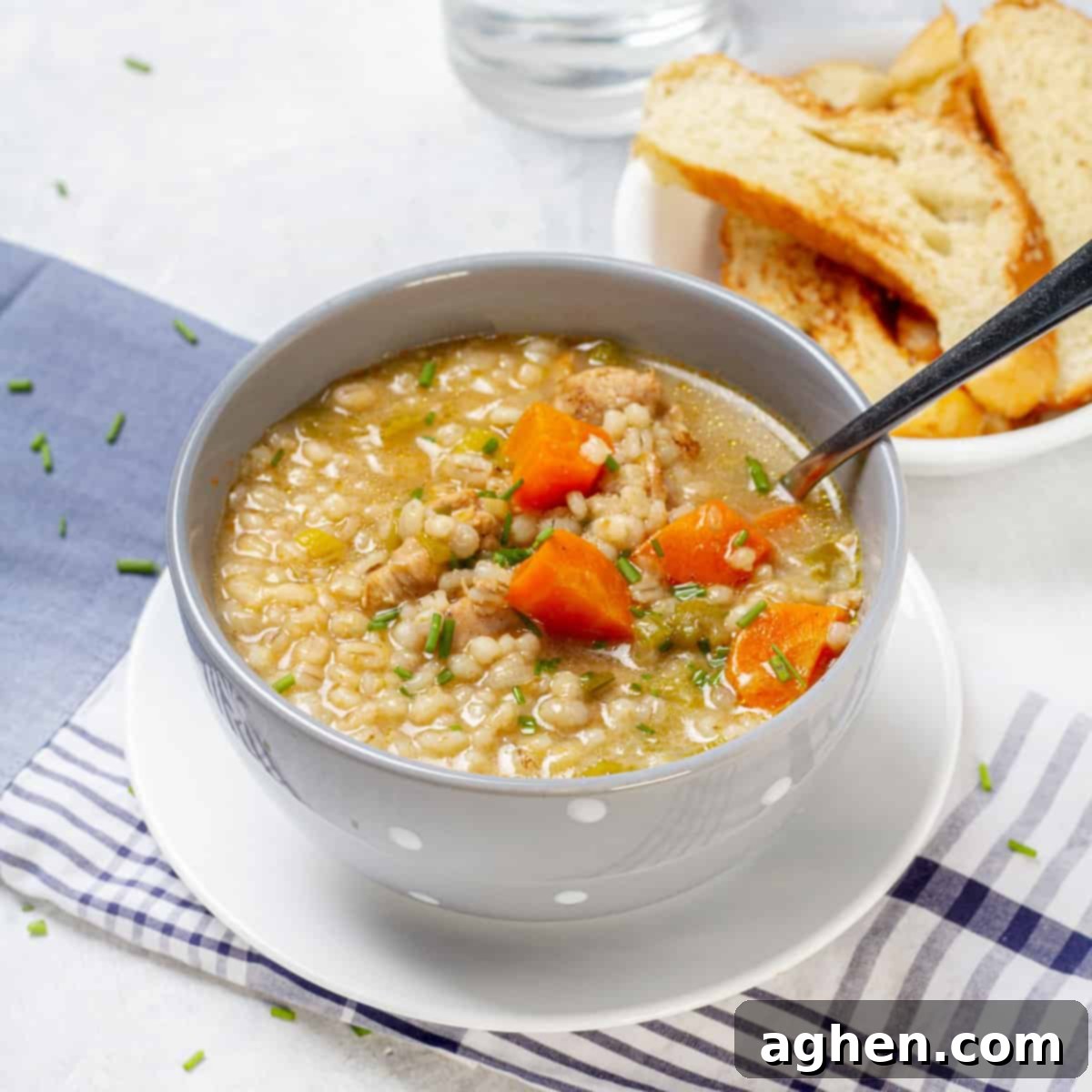 Warm and nourishing chicken and barley soup, served in a rustic bowl.