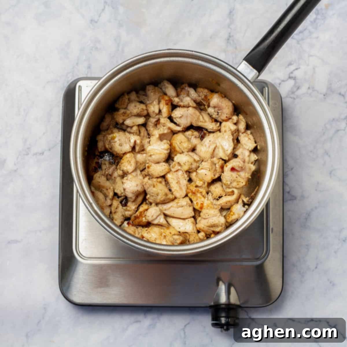 Chicken browning in a hot pot, creating a flavorful base for the soup.