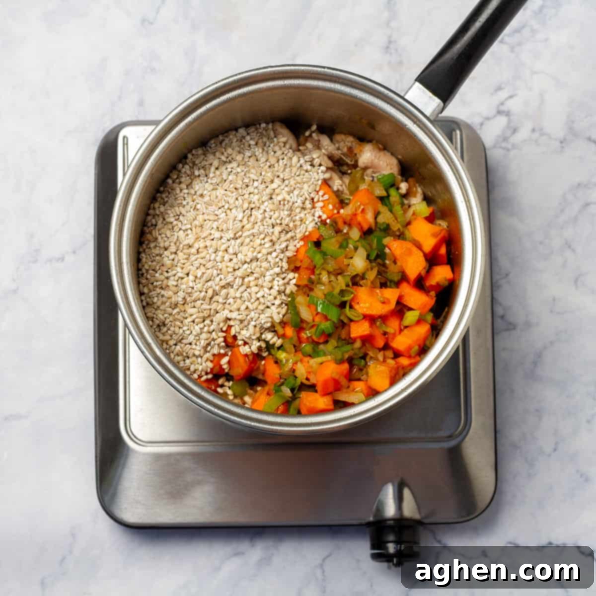 Pearl barley added to the cooked vegetables and chicken, ready to absorb the rich broth.