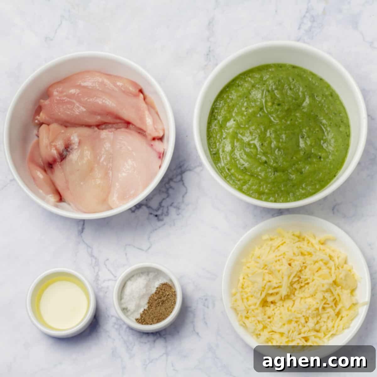 Ingredients of raw chicken breast, salsa verde sauce, mozzarella cheese, and seasonings in separate dishes. 