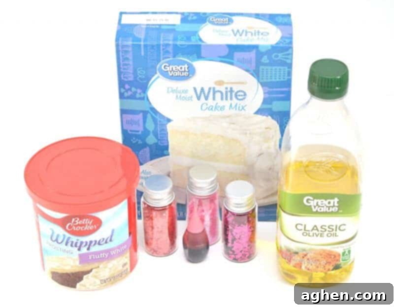 A collection of ingredients laid out for making pink princess playdough, including a box of white cake mix, a container of white whipped icing, a bottle of olive oil, pink food coloring, and a container of edible pink glitter. These supplies are ready for an easy no-cook DIY project.