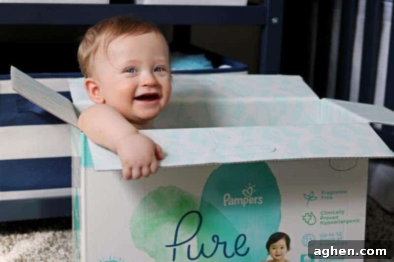 Smiling baby sitting playfully inside a Pampers diaper box