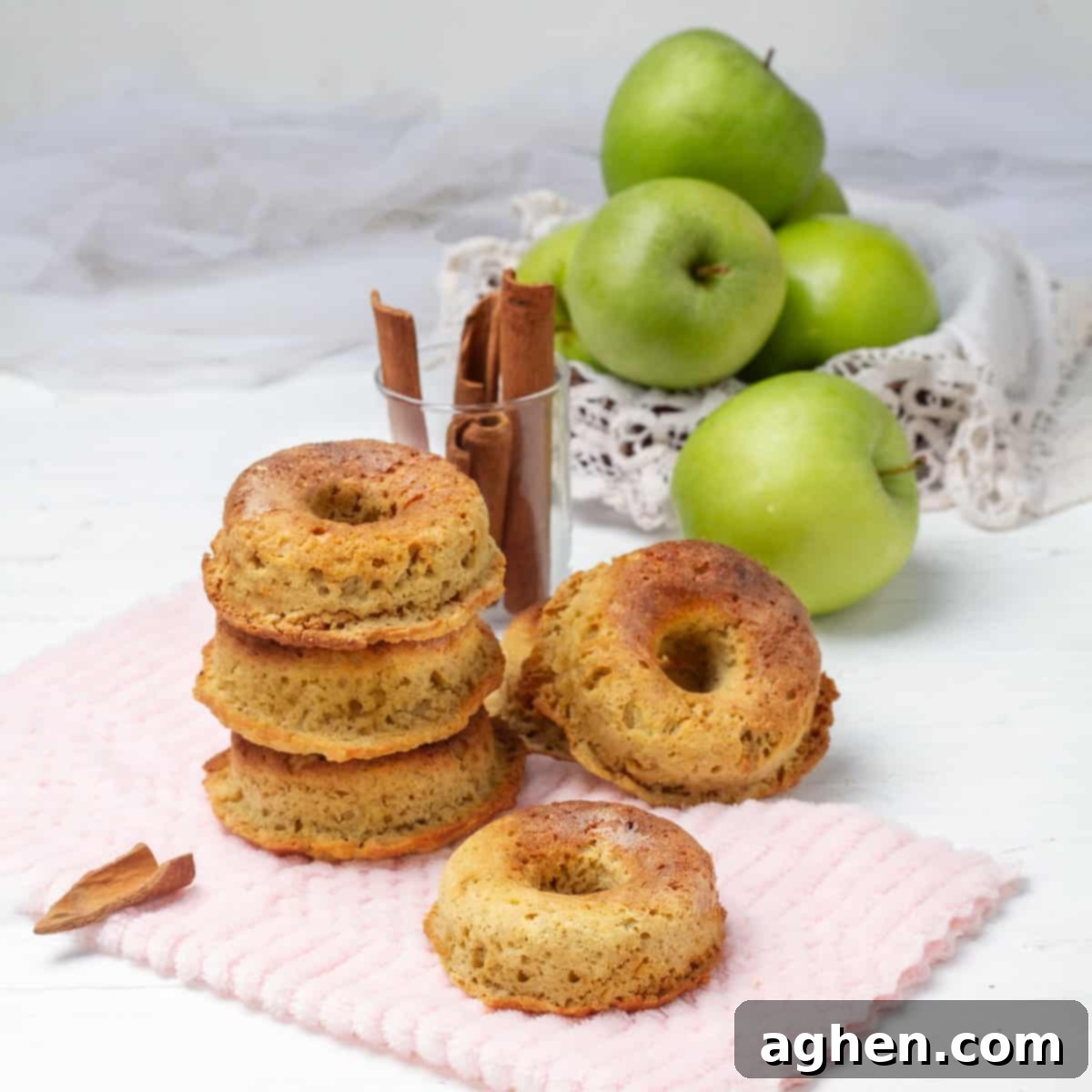 Freshly baked Apple Cider Donuts on a pink napkin, garnished with a sprinkle of cinnamon, ready to be served.
