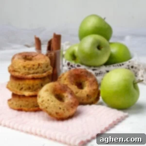 Close-up of a stack of baked apple cider donuts, garnished with cinnamon sugar.